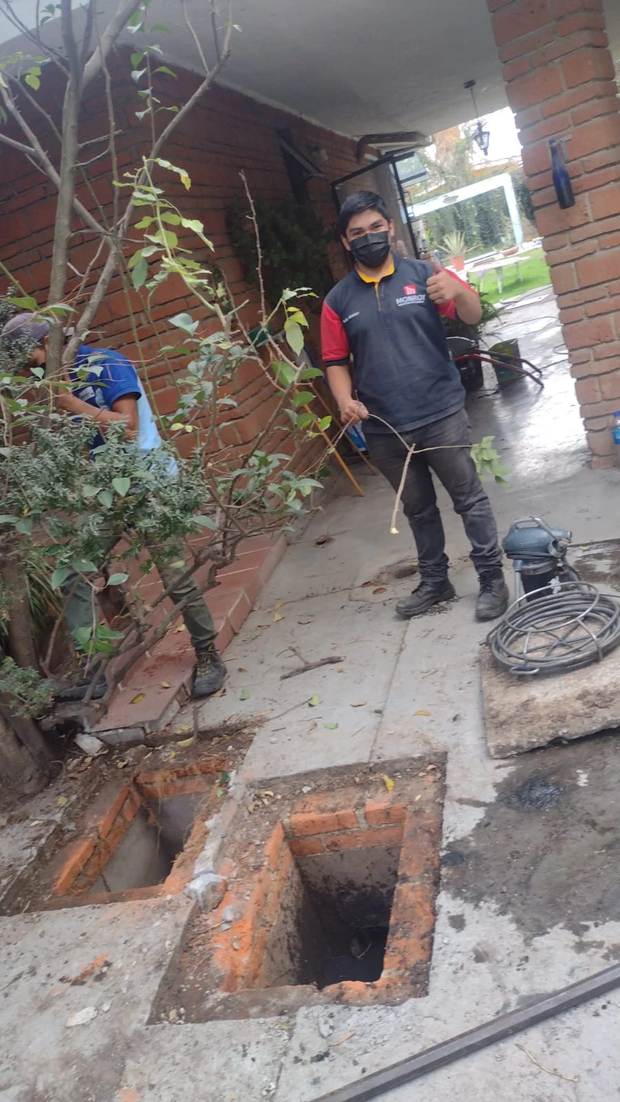 Equipo de desazolve trabajando en un registro de drenaje residencial