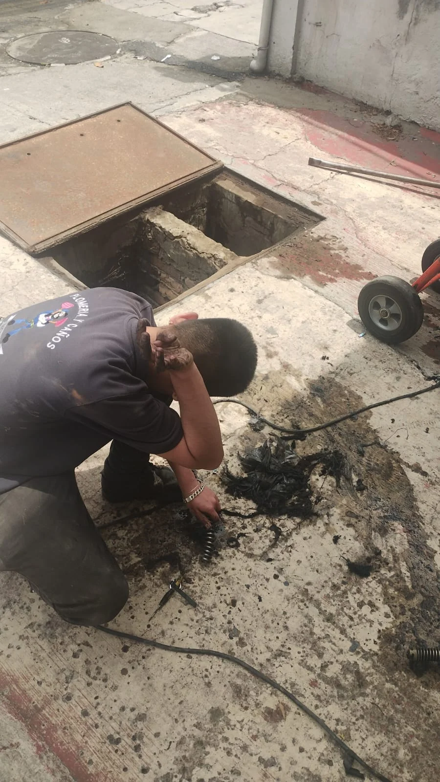Técnico revisando registro de drenaje durante un servicio de desazolve
